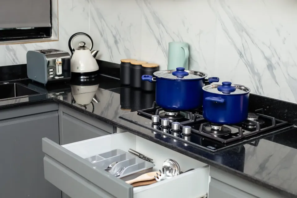 Gas hob, cookware and cutlery drawer in a Behomu apartment kitchen