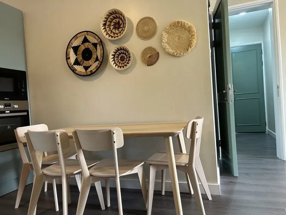 Dining area with light wooden table and woven wall decorations