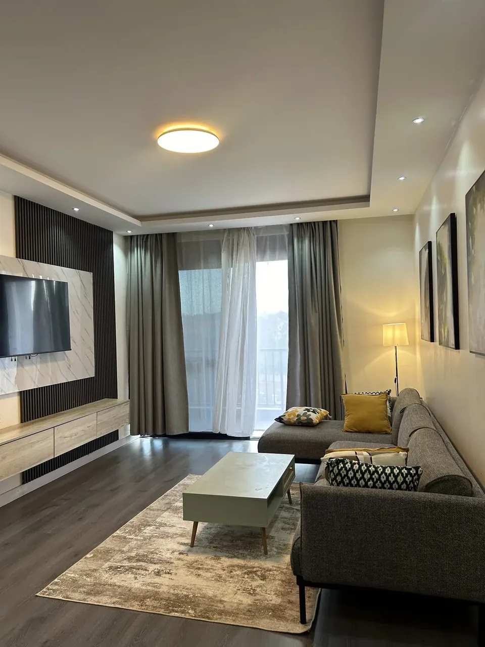 Living room with TV wall and doors opening to the balcony