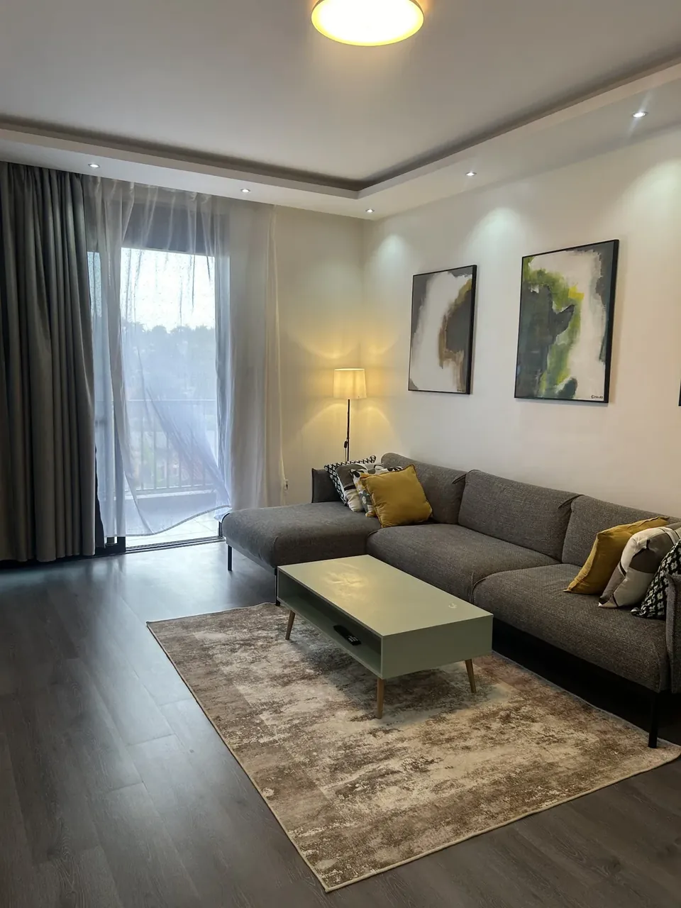 Living room with floor-to-ceiling curtains, floor lamp and grey sofa