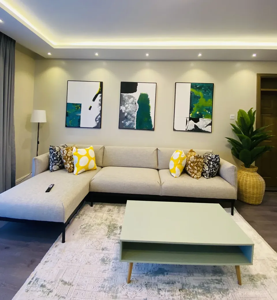 Spacious lounge with L-shaped sofa, coffee table and artwork